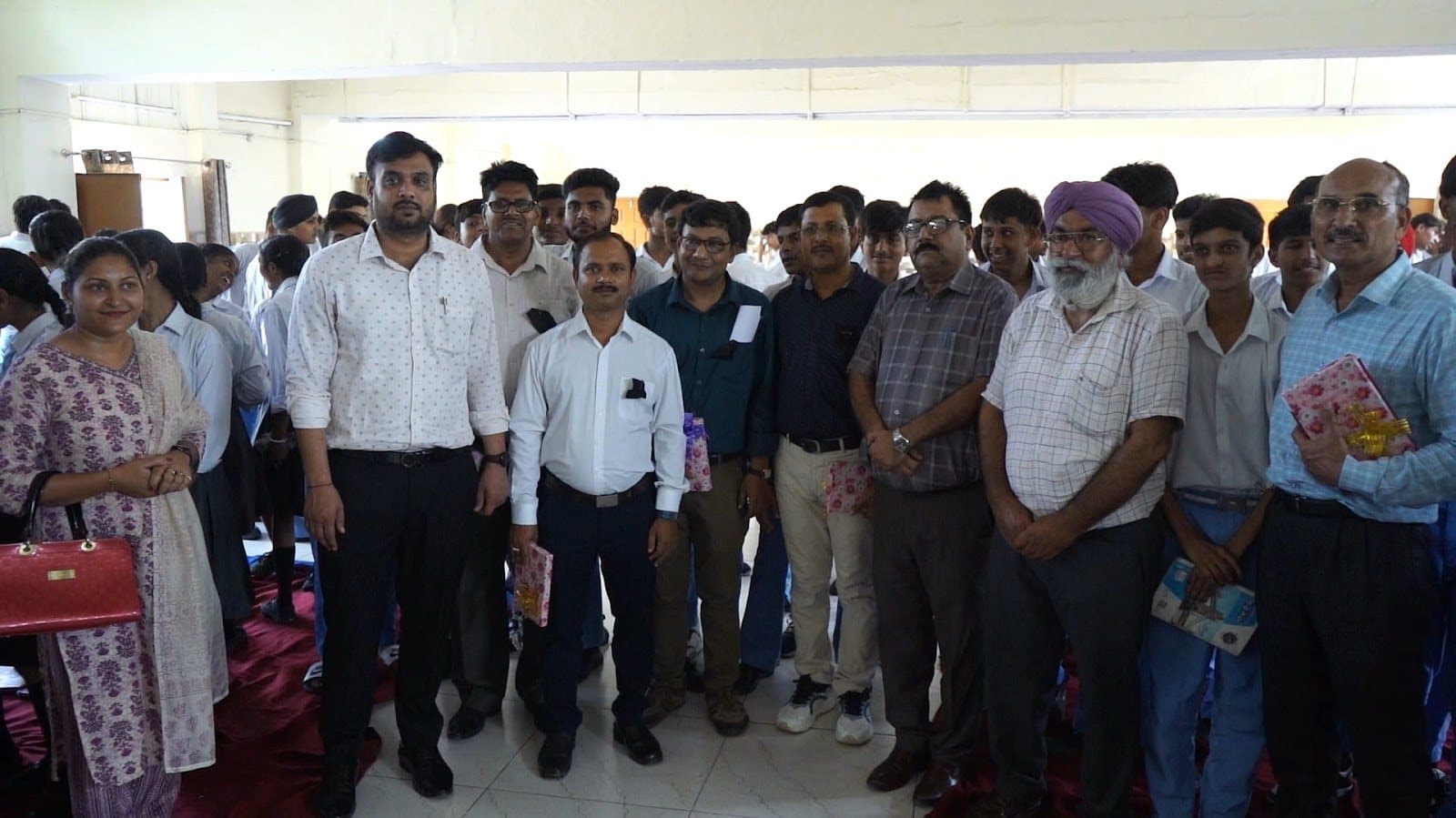A large group of adults and students standing together for a photograph.
