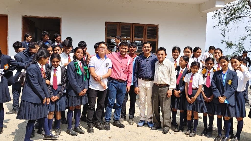 An outdoor group photograph of students in blazers with facilitators.