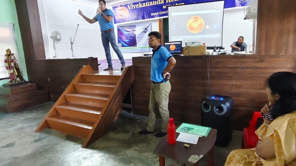 A session under way in a school hall, with a WSCosmos title slide projected on the screen.